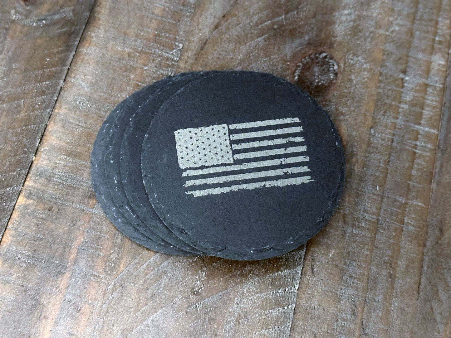 These USA themed slate coasters featured a US Flag design to show off that American pride. Laser engraved with either a light colored flag on a dark background or a dark colored flag on a light background, they’re a bold way to keep your drinks in check. Made from durable slate, these coasters are both functional and stylish, making them a perfect addition to any home or as a patriotic gift.