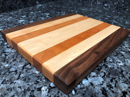 Long grain cutting board. Features black walnut, maple, cherry hardwoods.